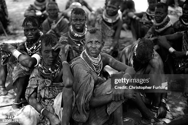 Men and women from the remote Turkana tribe in Northern Kenya wait their turn to see if they will be selected for food aid by other villagers at...