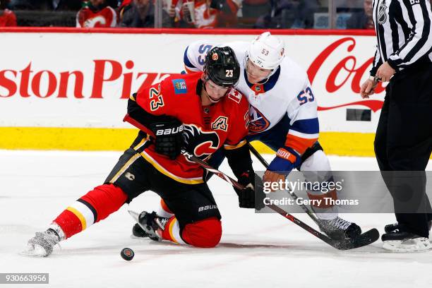 Sean Monahan of the Calgary Flames skates against Casey Cizikas of the New York Islanders during an NHL game on March 11, 2018 at the Scotiabank...