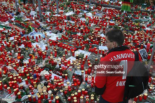 Fan of the Hannover 96 football club looks at a sea of candles for goalie Robert Enke shortly before a memorial service prior to Enke�s funeral at...