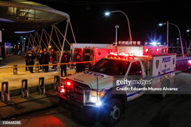 Officers remove the bodies from the scene of a helicopter crash in the East River on March 11, 2018 in New York City. According to reports, two...