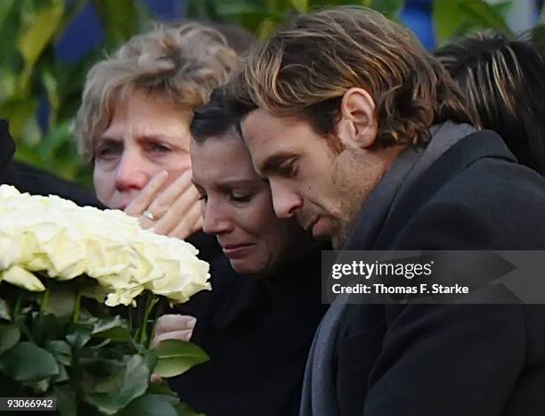 Widow Teresa Enke cries next to Jacques Gassmann during the memorial service prior to Robert Enke's funeral at AWD Arena on November 15, 2009 in...