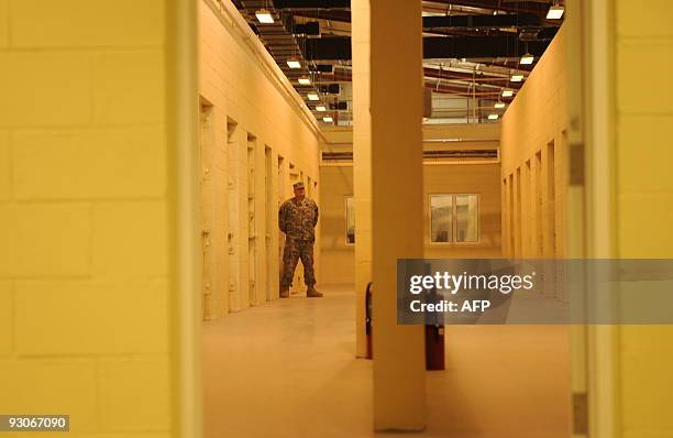 Soldier stands guard beside prison cells during a media tour of Bagram prison, north of Kabul, on November 15, 2009. A human rights group is calling...