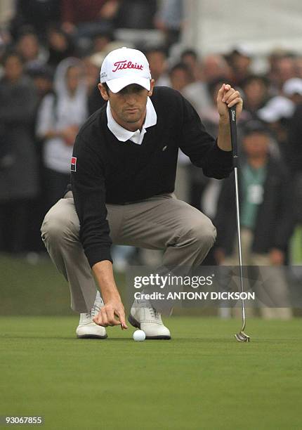 France's Gregory Bourdy places a marker before a putt during the final round of the Hong Kong Open golf tournament at the Hong Kong Golf Club in...