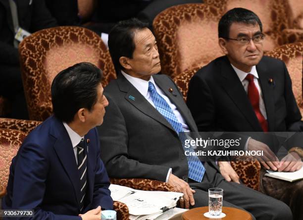 This picture taken on March 8, 2018 shows Japan's Prime Minister Shinzo Abe , Finance Minister Taro Aso , and Foreign Minister Taro Kono attending an...