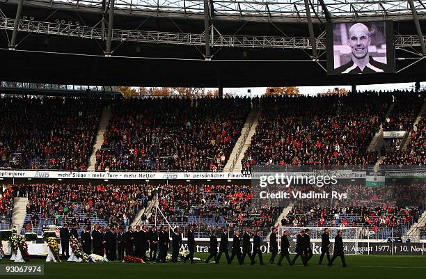 Manager Joerg Schmadtke followed by Hannover 96 football club players leaves the pitch after their goalie Robert Enke's coffin has been brought away...