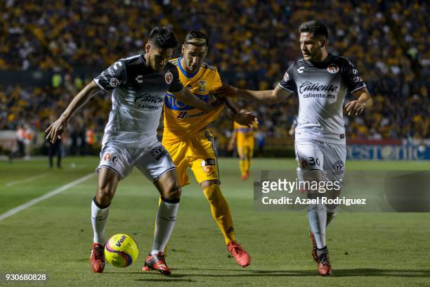 Ismael Sosa of Tigres fights for the ball with Juan Carlos Valenzuela and Hiram Muñoz of Tijuana during the 11th round match between Tigres UANL and...