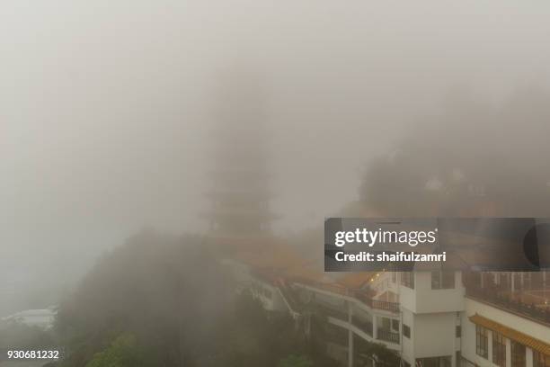 the chin swee caves temple over clouds and heavy fog. the temple is situated in the most scenic site of genting highlands, malaysia. within the temple is seated a statue of qingshui, a buddhist monk who has long been referred to as a deity. - malaysia architecture stock pictures, royalty-free photos & images
