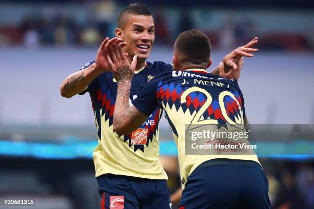 Matheus Uribe of America celebrates with teammates after scoring the first goal of his team during the 11th round match between America and Leon as...