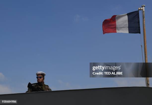 An armed French sailor of the navy frigate Vendemiaire stands guard on the deck as it prepares to dock at the international port in Manila on March...