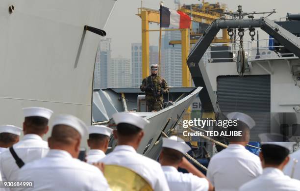 An armed French sailor of the navy frigate Vendemiaire stands guard on the deck as it prepares to dock at the international port in Manila on March...