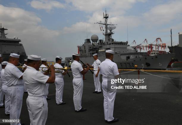 Members of the Philippine navy band play welcoming music as French navy frigate Vendemiaire prepares to dock at the international port in Manila on...