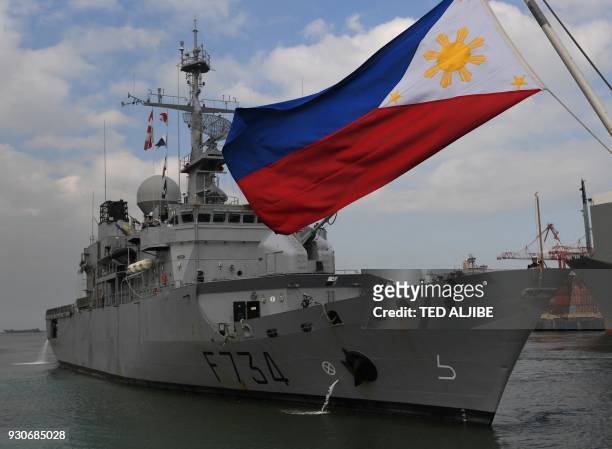 French navy frigate Vendemiaire prepares to dock while a Philippine flag flutters at the international port in Manila on March 12, 2018. - FNS...