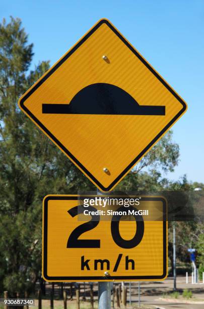 speed bump ahead traffic warning sign and 20 kilometre per hour speed limit sign - speed bump foto e immagini stock