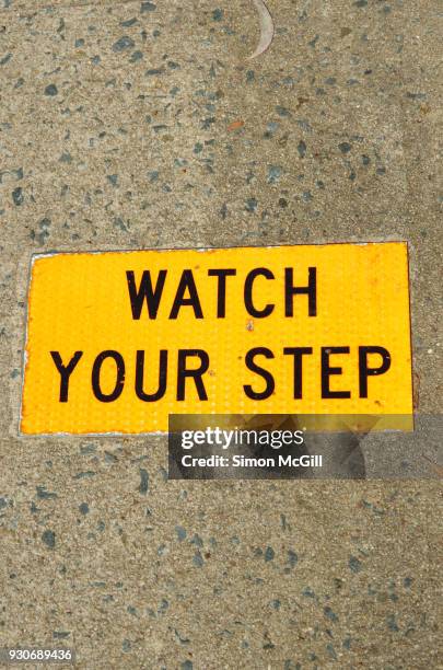 watch your step sign on a concrete footpath - trip hazard stock pictures, royalty-free photos & images