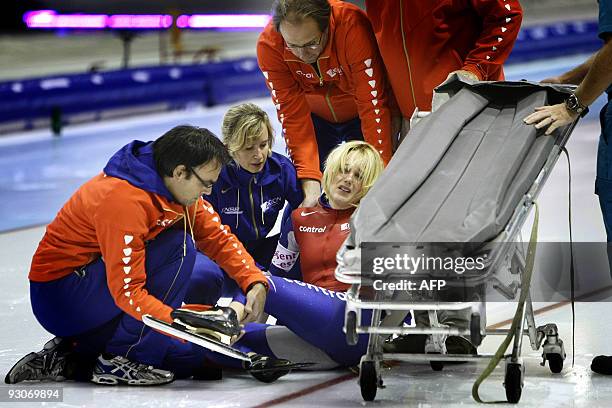 Dutch Marianne Timmer is helped by team coach Jac Orie after she fell during her 500 meter race at the ISU World Cup speedskating in Heerenveen, on...
