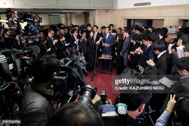 Japan's Finance Minister Taro Aso answers questions as he is surrounded by the media during a press briefing at the finance ministry in Tokyo on...