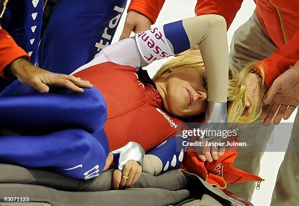Olympic champion Marianne Timmer of the Netherlands receives help as she lies on the ice after crashing with Jing Yu of China in the 500m race during...