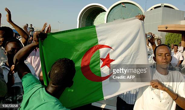 Supporters of Algeria's football team hold an Algerian flag upon the arrival of their team at Khartoum airport on November 15, 2009. The Pharoahs...
