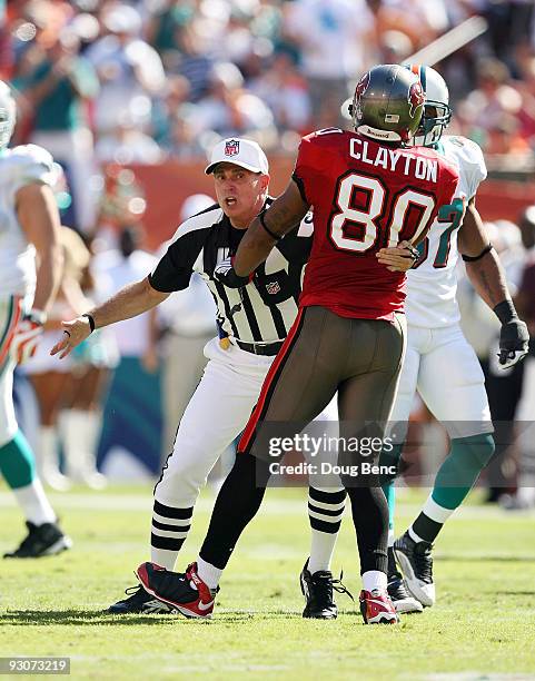 Referee Tony Corrente tries to seperate wide receiver Michael Clayton of the Tampa Bay Buccaneers from getting into a fight with Dolphin players...