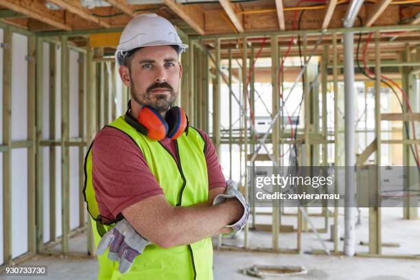 portrait of construction worker with arms crossed - builders stock pictures, royalty-free photos & images