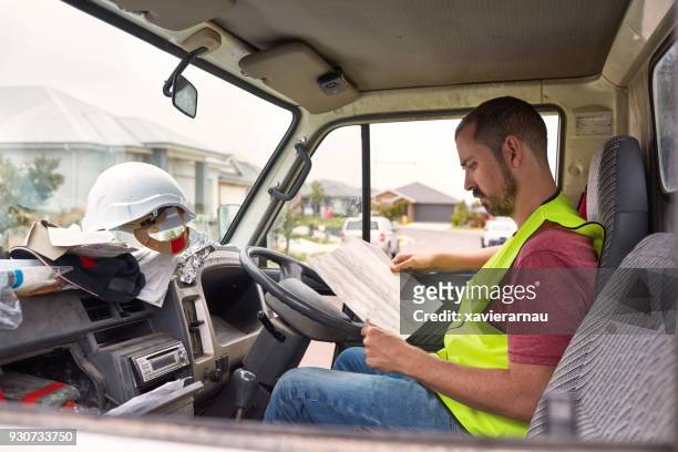 construction worker reading paper in pick-up truck - pick up truck stock pictures, royalty-free photos & images