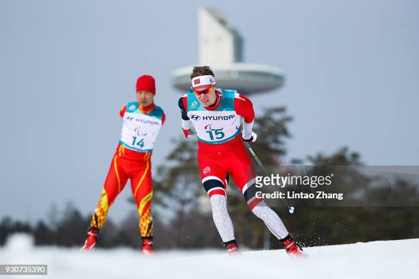 Hakon Olsrud of Norway and Du Haitao of China competes in the Men's Cross Country 20km Free, Standing event at Alpensia Biathlon Centre during day...