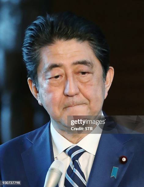 Japan's Prime Minister Shinzo Abe apologizes during a press briefing at his office in Tokyo on March 12, 2018. - Finance Minister Taro Aso admitted...