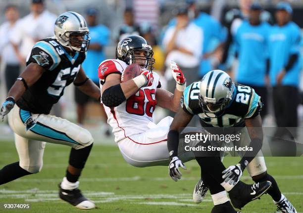 Tony Gonzalez of the Atlanta Falcons is tackled after a catch by teammates Chris Gamble and Na'il Diggs of the Carolina Panthers during their game at...