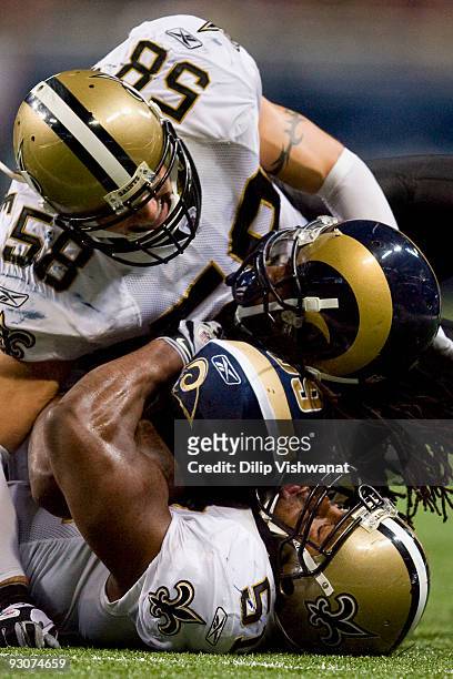 Steven Jackson of the St. Louis Rams is tackled by Scott Shanle and Jonathan Vilma both of the New Orleans Saints at the Edward Jones Dome on...