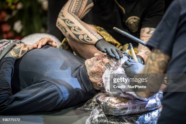 Man receives a tattoo during the Paris Tattoo Convention on March 10, 2018 at the Grand Halle de la Villette in Paris. The 8th edition of the Mondial...