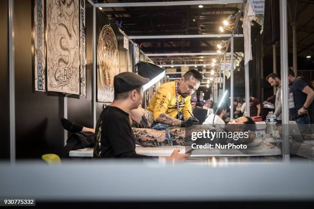 Man receives a tattoo during the Paris Tattoo Convention on March 10, 2018 at the Grand Halle de la Villette in Paris. The 8th edition of the Mondial...