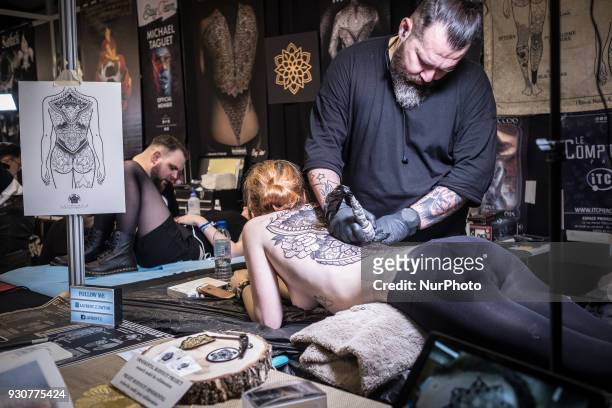 Woman receives a tattoo during the Paris Tattoo Convention on March 10, 2018 at the Grand Halle de la Villette in Paris. The 8th edition of the...