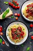 Spaghetti pasta meatballs with tomato sauce, basil, herbs parmesan cheese on dark background