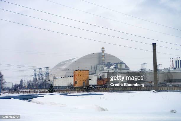 The containment structure which entombs the destroyed nuclear reactor stands near electricity power lines in Chernobyl, Ukraine, on Wednesday, Feb....