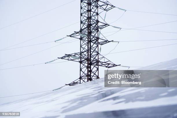 Snow covers solar panels near a pylon carrying high voltage electricity in Chernobyl, Ukraine, on Wednesday, Feb. 28, 2018. Solar Chernobyl SPP, a...