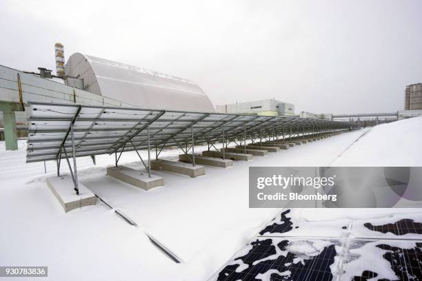 Solar panels, operated by Solar Chernobyl SPP, operate near the containment structure which entombs the destroyed nuclear reactor in Chernobyl,...