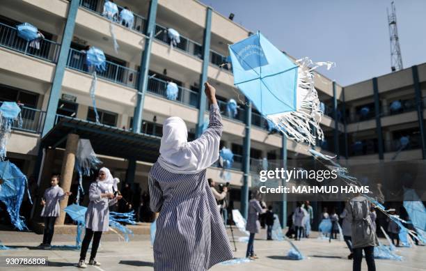 Palestinian schoolgirls fly kites outside their classrooms at a school belonging to the United Nations Relief and Works Agency for Palestinian...