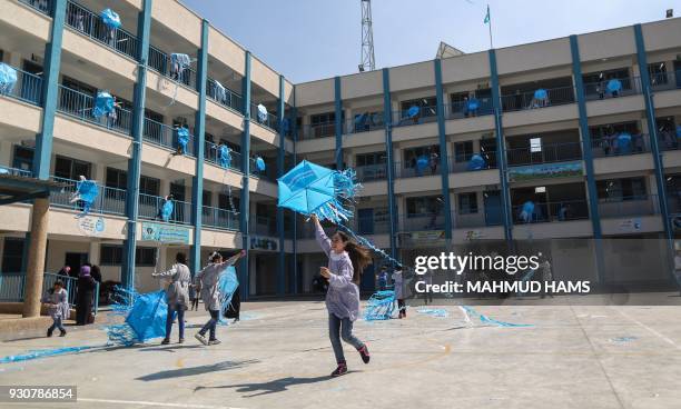 Palestinian schoolgirls fly kites outside their classrooms at a school belonging to the United Nations Relief and Works Agency for Palestinian...