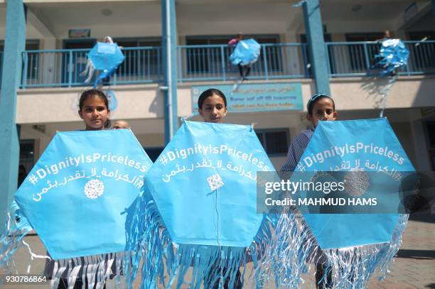 Palestinian schoolgirls fly kites outside their classrooms at a school belonging to the United Nations Relief and Works Agency for Palestinian...