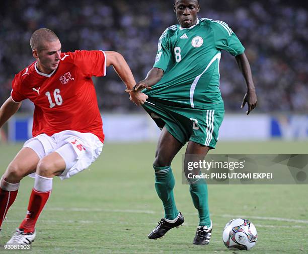 Nigeria's Stanley Okoro is held by the shirt as he tries to dribble past Switzerland's Pajtim Kasami during the final of FIFA U-17 World Cup in Abuja...
