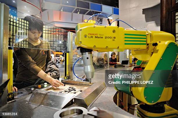 In this picture taken on November 13, 2009 a visitor plays a Chinese chess game against a robot at the Science and Technology Museum in Shanghai....