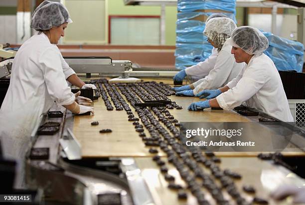 The christmas cookies with chopped nuts and coated chocolate are hand-packed in a visual control at the gingerbread bakery Henry Lambertz on November...