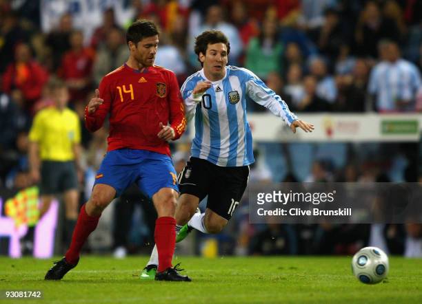 Lionel Messi of Argentina in action with Xabi Alonso of Spain during the friendly International football match Spain against Argentina at the Vicente...