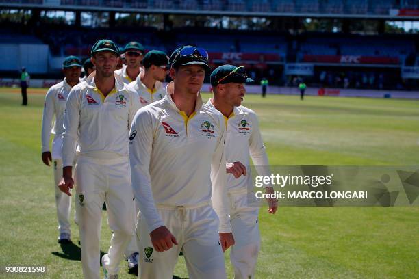 Australia's captain Steve Smith leads his team including David Warner , off the field after their defeat on the fourth day of the second Test cricket...
