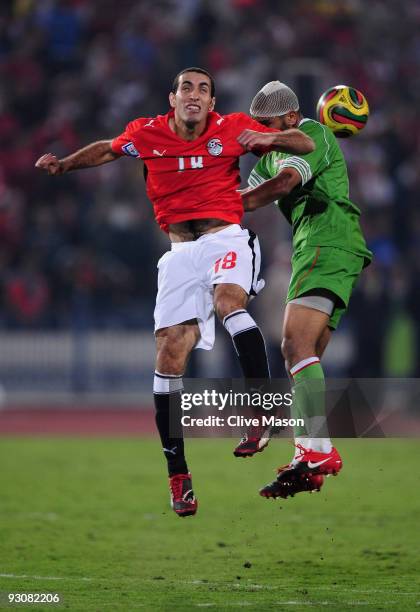 Mohamed Aboutrika of Egypt jumps with Kaled Lemmouchia of Egypt during the FIFA2010 World Cup qualifying match between Egypt and Algeria at the Cairo...