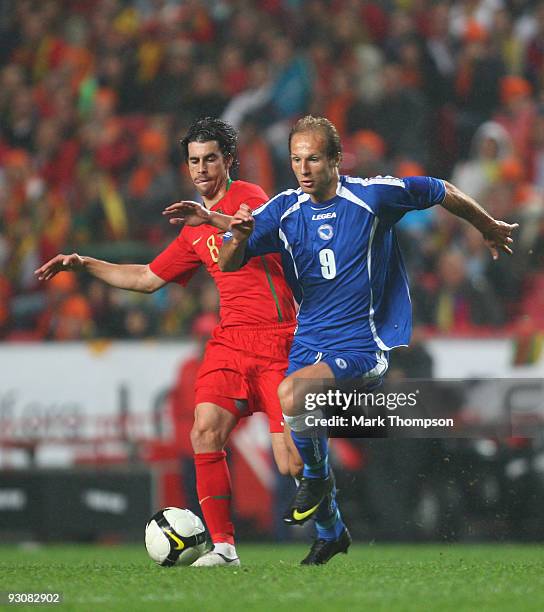Tiago of Portugal tangles with Zlatan Muslimovic of Bosnia during the FIFA 2010 European World Cup qualifier first leg match between Portugal and...