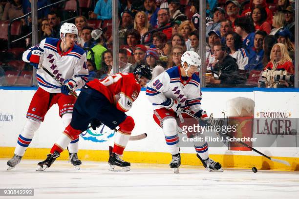 Vladislav Namestnikov and Rob O'Gara of the New York Rangers tangle with Maxim Mamin of the Florida Panthers at the BB&T Center on March 10, 2018 in...