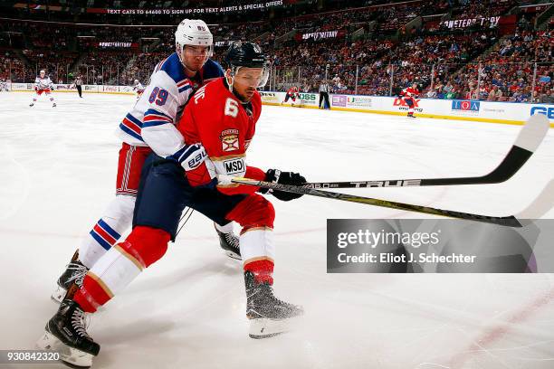 Alex Petrovic of the Florida Panthers skates for possession against Pavel Buchnevich of the New York Rangers at the BB&T Center on March 10, 2018 in...