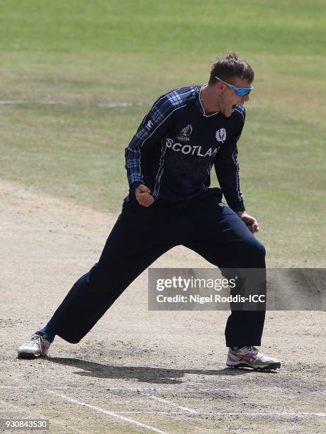 Michael Leask of Scotland celebrates taking the wicket of Solomon Mire during the ICC Cricket World Cup Qualifier between Zimbabwe and Scotland at...