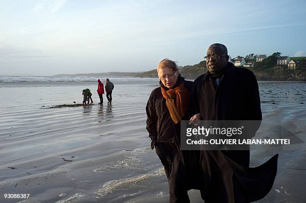 Franco-Togolese dual national politician Kofi Yamgnane walks with his wife Anne-Marie on the beach of Saint-Nic, western France, on November 14,...